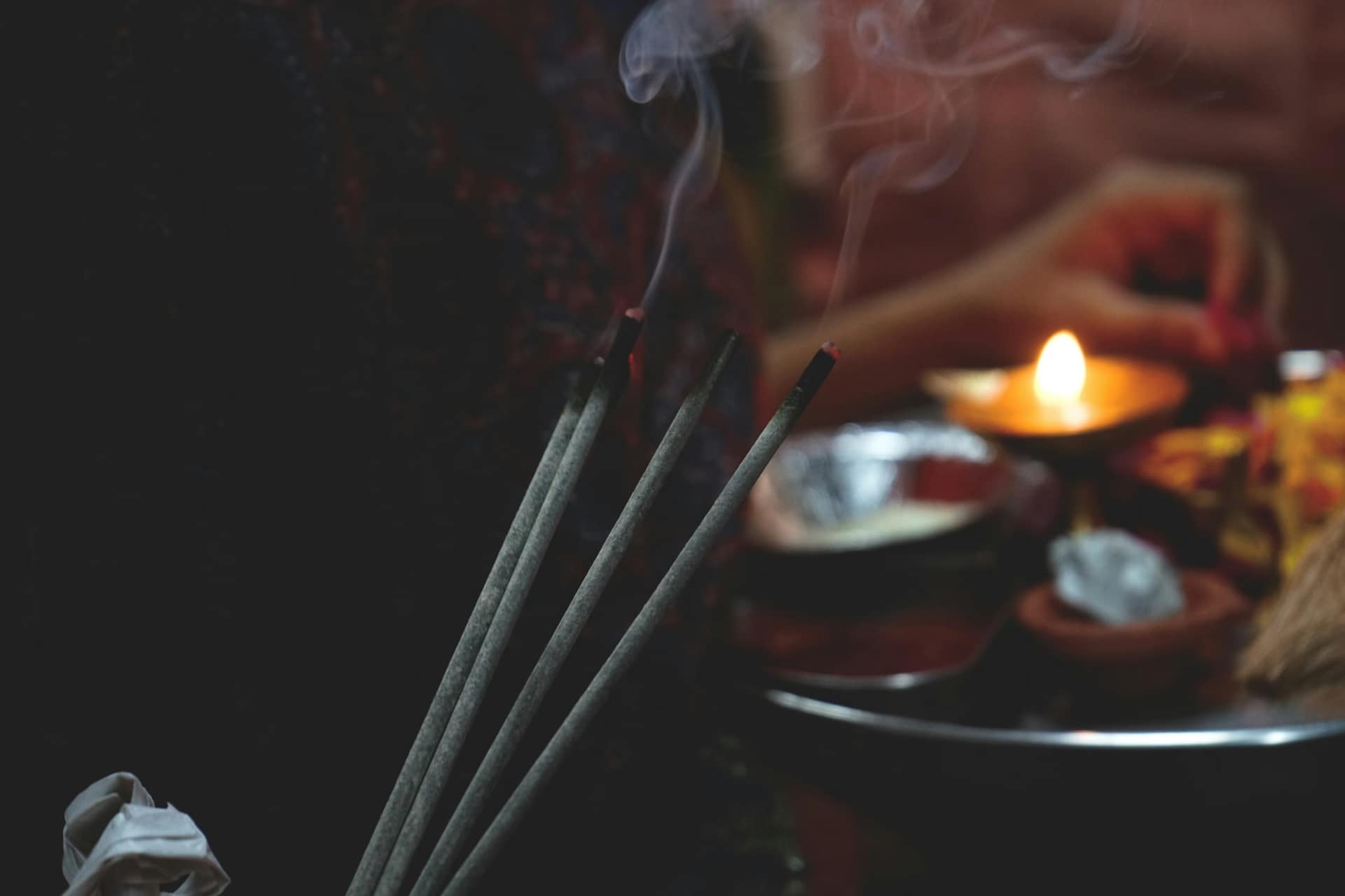 Smoke curling from burning incense stick during morning ritual.